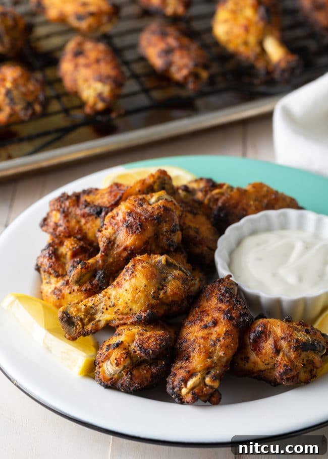 Platter of baked lemon pepper chicken wings, garnished with parsley