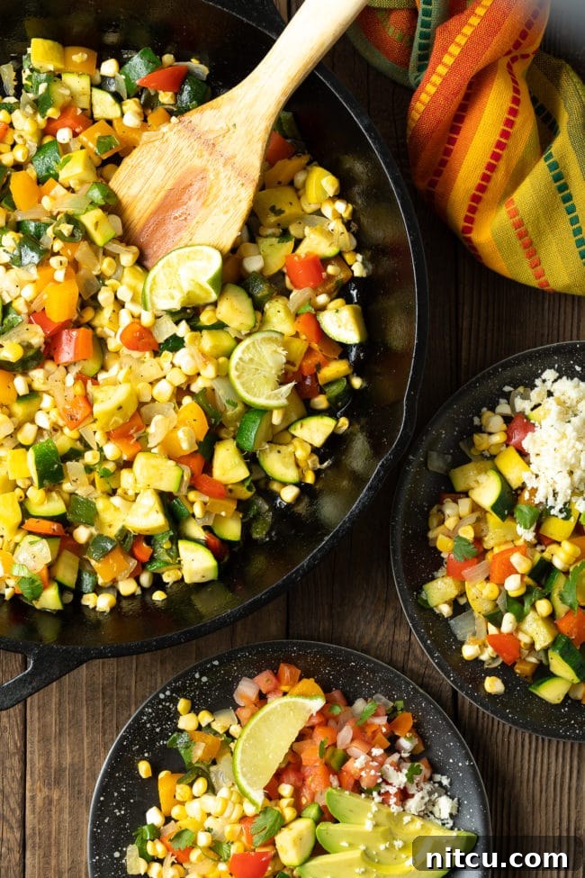 Sauteed vegetables in a cast iron skillet with some of it served on plates next to it, invitingly presented.