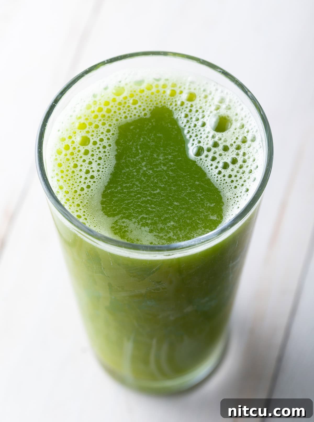 Top down view of celery juice in a glass. 