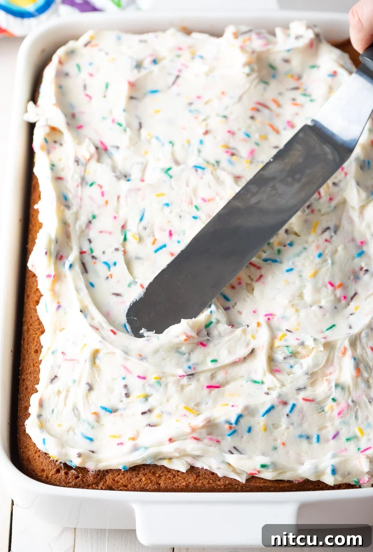 A freshly frosted homemade vanilla cake, ready to be enjoyed.