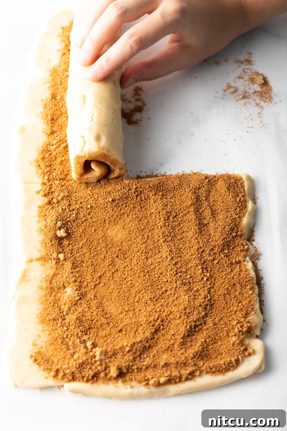 Cinnamon sugar mixture sprinkled evenly over cookie dough