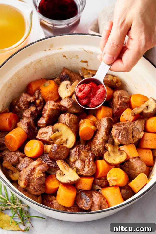 Deer Stew Recipe in a dutch oven with tomato paste added 