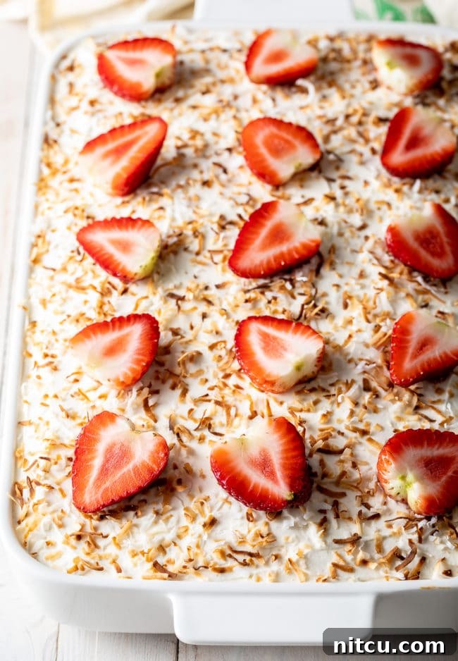 Strawberry Cake with jello and whipped topping in the pan, showcasing its beautiful layers and garnish.