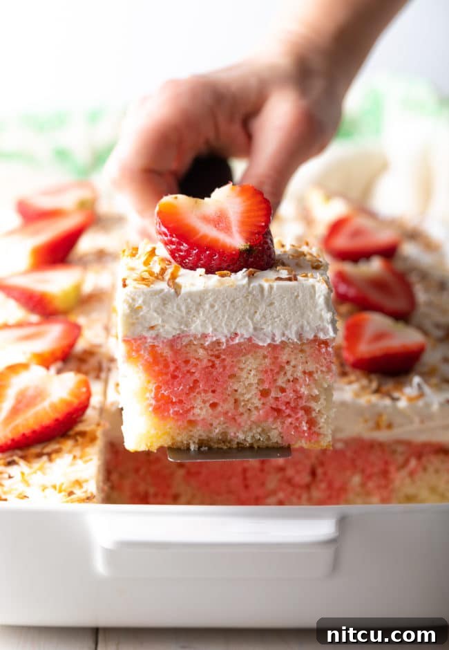 Easy Poke Cake lifted out of pan, perfectly sliced and ready to serve.