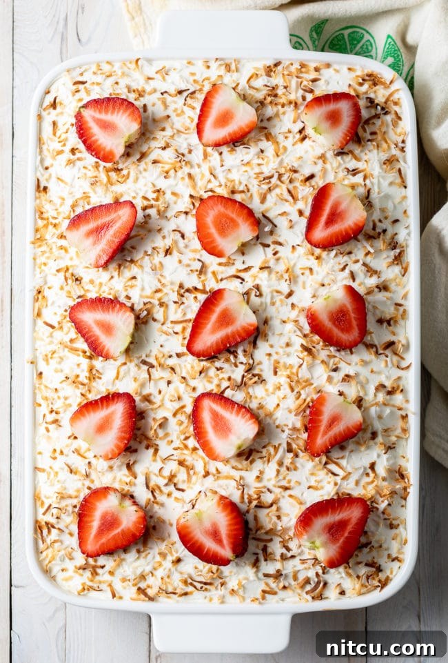 Strawberry Jello Cake with Pineapple and Coconut in a white cake pan, ready for its delicious topping.