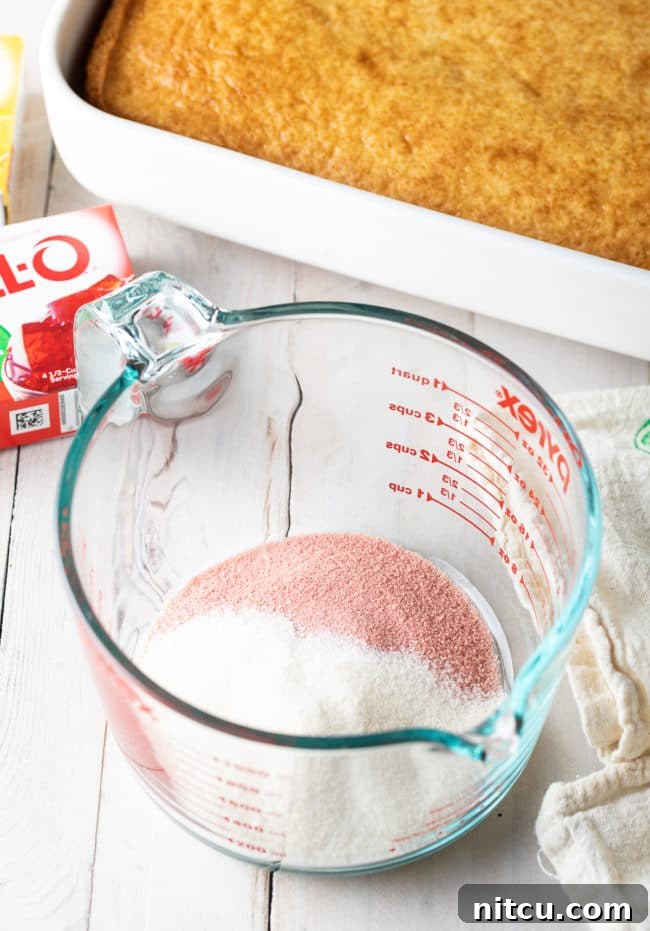 Jello Cake Recipe ingredients neatly arranged in a measuring pitcher, ready for mixing.