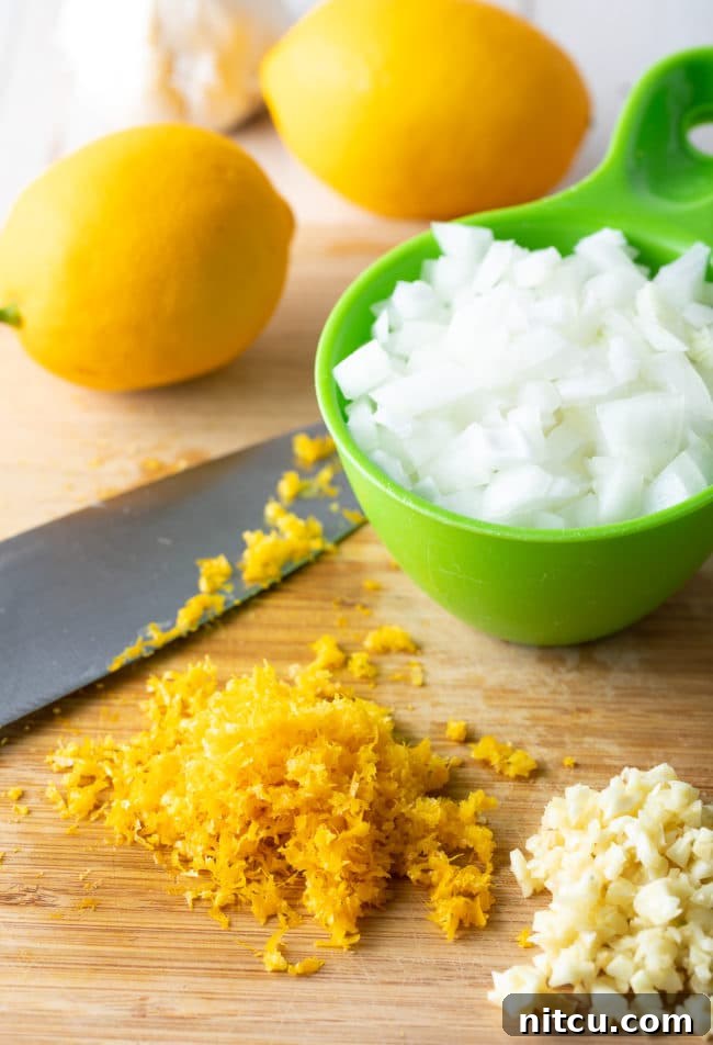 Lemons, chopped onion, and minced garlic prepped for the Lemon Parmesan Chicken and Rice Skillet.