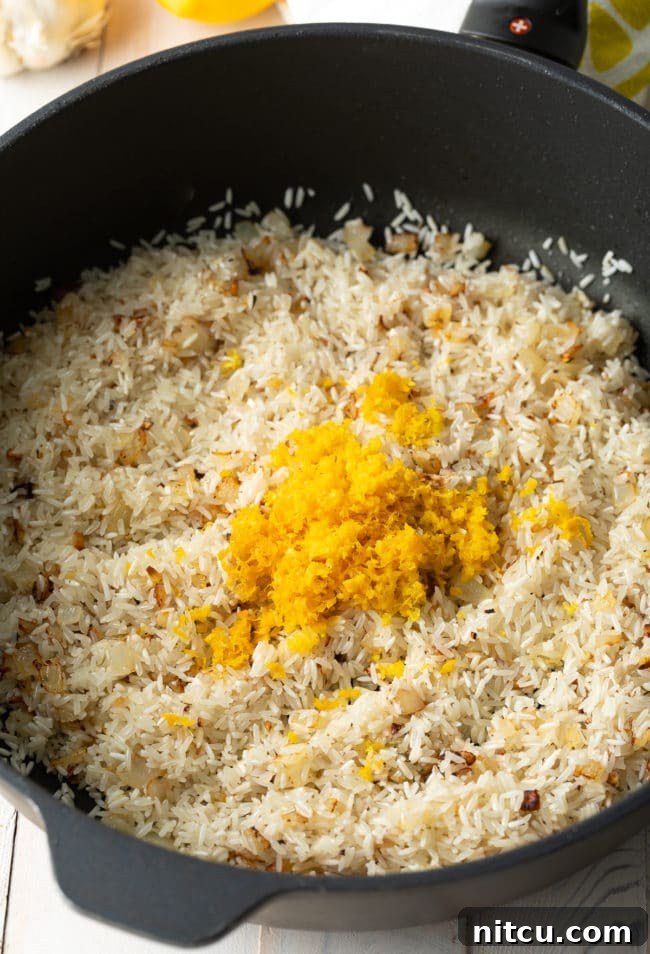 Rice, lemon zest, rosemary, and bouillon stirred into the skillet after browning the chicken.