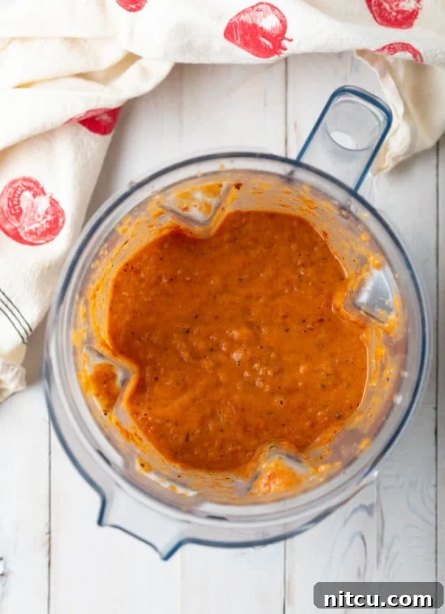 Smooth, rich tomato soup after being blended, ready to be transferred to a pot.