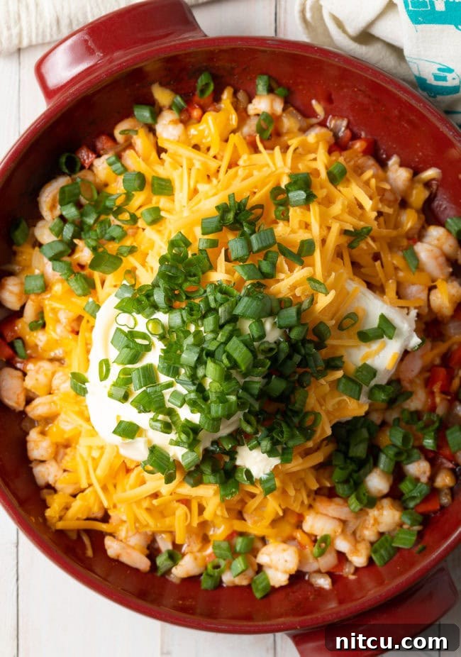 adding a cheesy layer on top of the dip before baking the hot shrimp dip. 