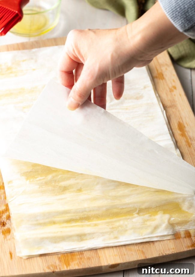 Perfectly stacked and brushed phyllo sheets, forming the crispy, flaky base and top layers for the savory pie.