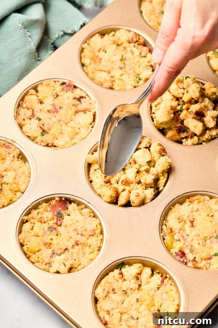 The process of pressing stuffing mixture into individual muffin pans, ensuring a compact and even fill