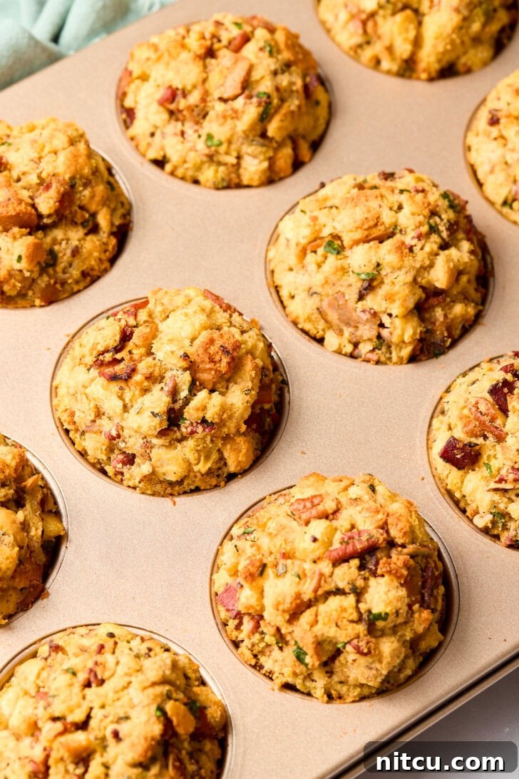 A tray of freshly baked, golden brown stuffing muffins still in their muffin pans, hot from the oven