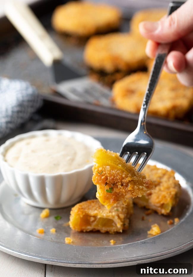 Fork with a piece of crispy fried green tomato on it. 
