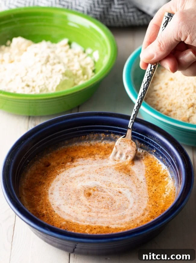 Hand whisking together buttermilk and cajun seasoning. 