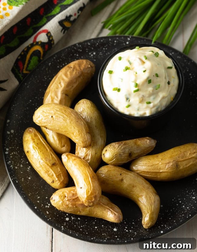 Aioli sauce in a bowl with a plate of fingerling potatoes.