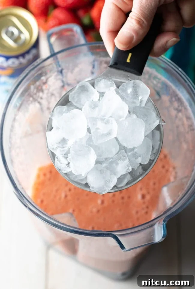 Cup of ice being added to the blender. 