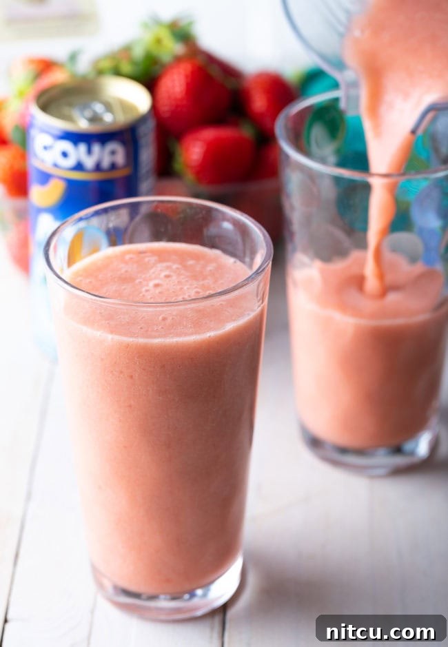 Caribbean Way Smoothie in a glass with another glass being filled. 