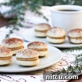 Delicious Tiramisu Cookies stacked on a platter, dusted with cocoa powder.