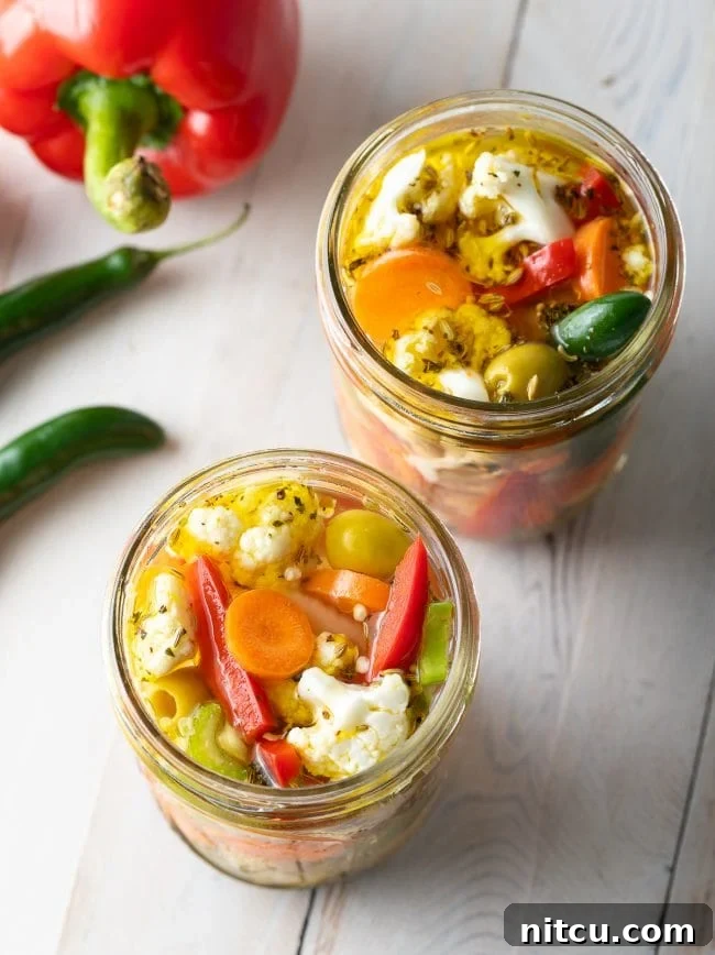 An overhead shot of multiple jars filled with homemade Giardiniera Pickled Vegetables, ready for enjoyment.