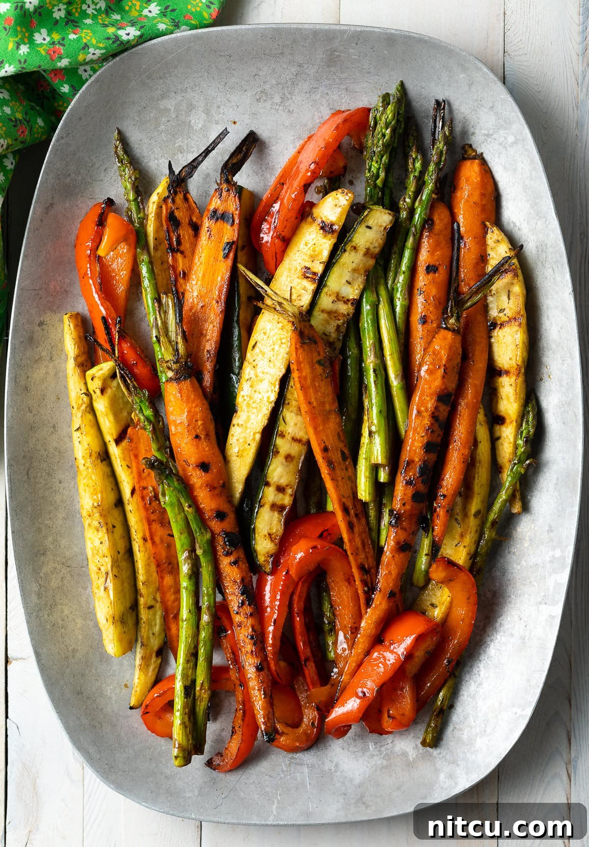 Assortment of vibrant marinated grilled vegetables on a large serving platter, ready to be enjoyed.