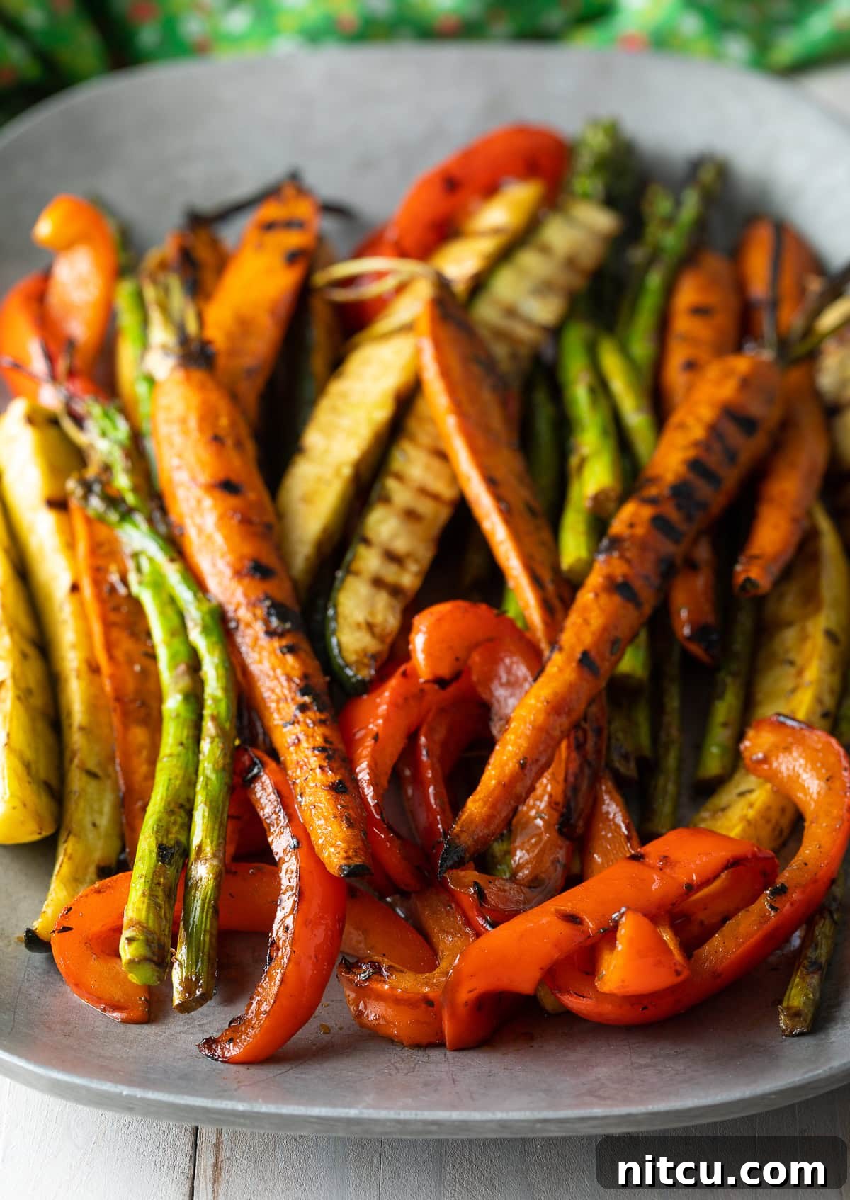 Beautifully marinated and grilled carrots, asparagus, bell peppers, and zucchini on a hot grill, showing perfect char marks.