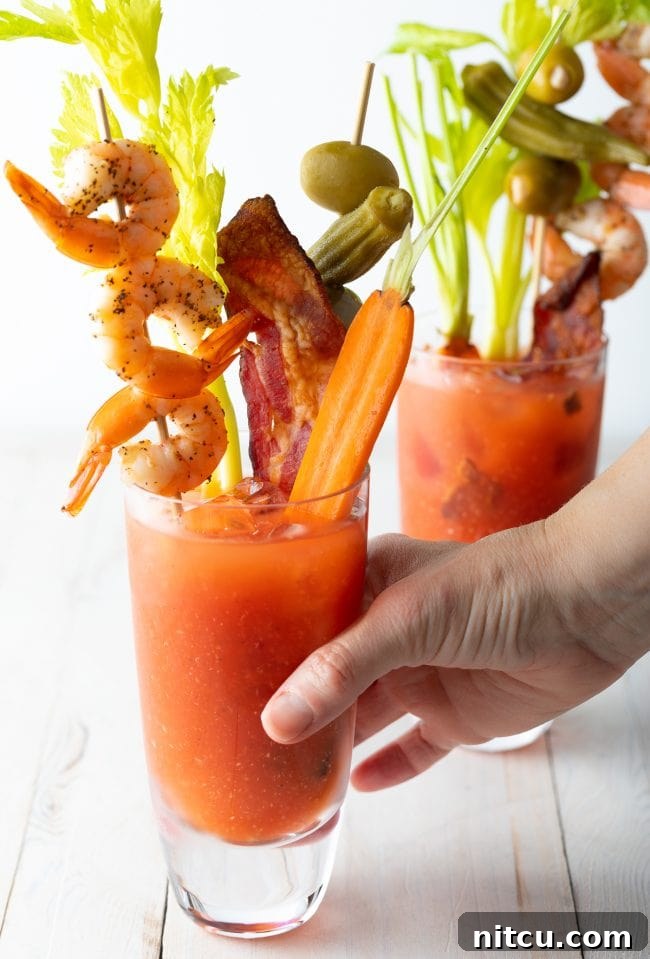Hand grabbing a bloody mary drink. 