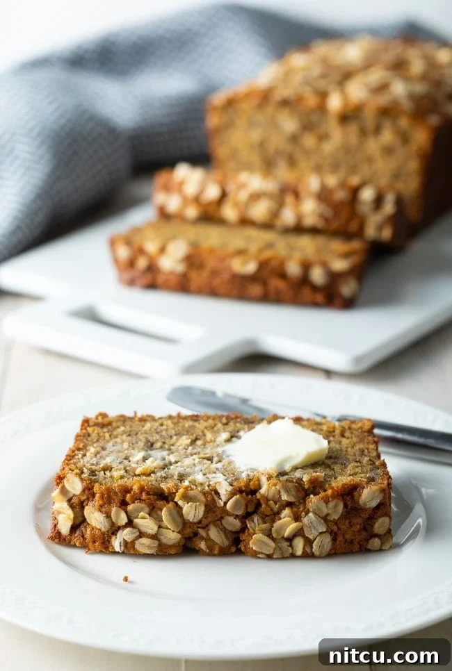 A delectable slice of banana bread on a plate, elegantly topped with a delicate smear of melted butter.
