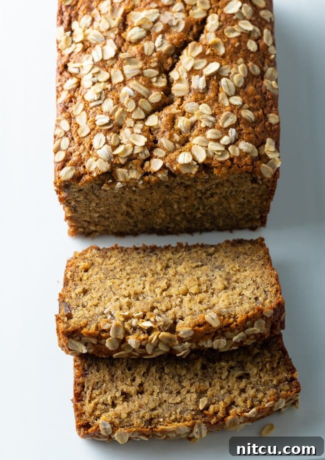 Freshly baked Oatmeal Banana Bread with two inviting slices removed from the end.