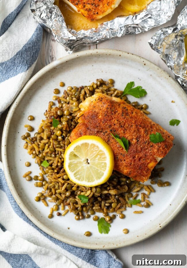 Lemon Pepper Grilled Cod in foil, showing perfectly cooked fish with lemon slices and herbs.
