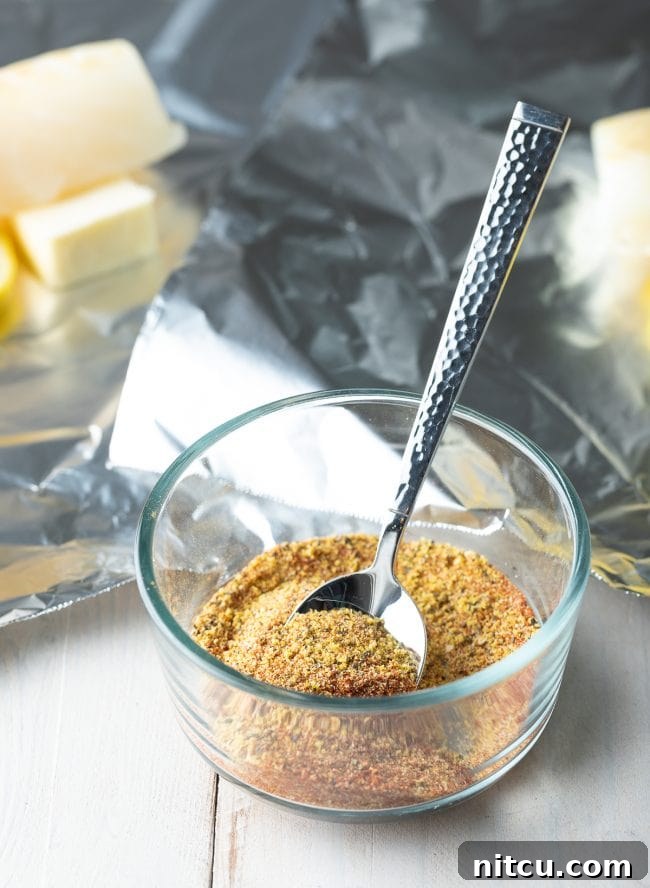 Measuring out a spice blend for lemon pepper fish, including lemon pepper, garlic powder, and smoked paprika.