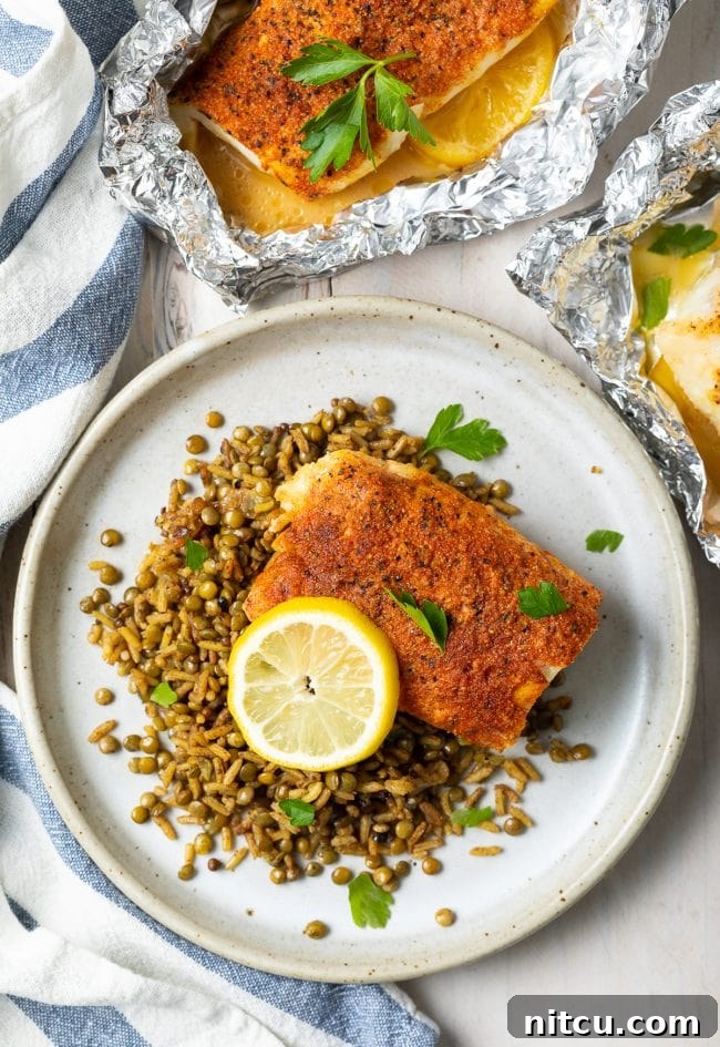 Grilled whitefish fillets garnished with fresh lemon slices and herbs, ready to eat.