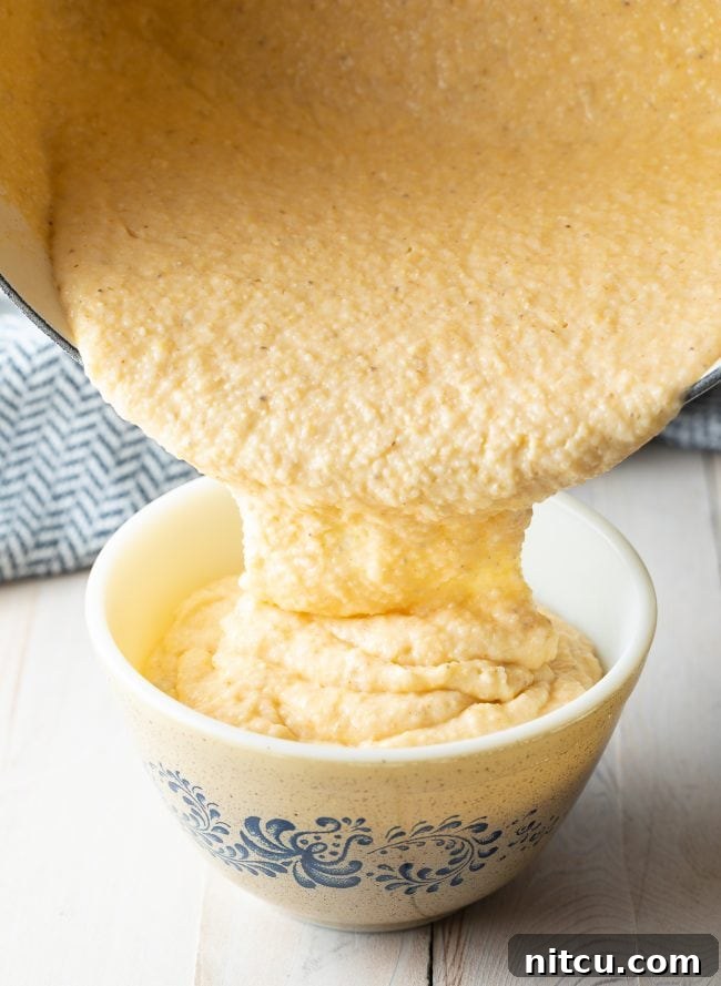 Grits being poured from a pot into a serving bowl. 