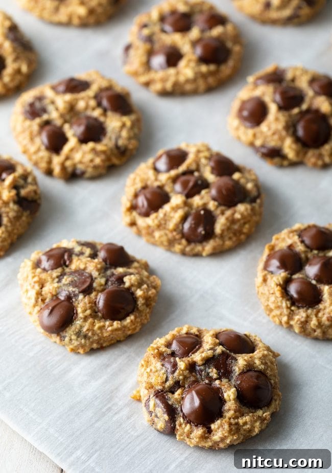 Banana oatmeal cookies lined up on a baking sheet. 