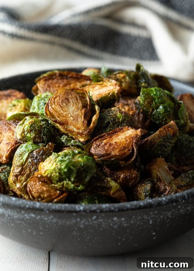 Closeup of bowl filled with crispy fried Brussels sprouts, ready to be seasoned.