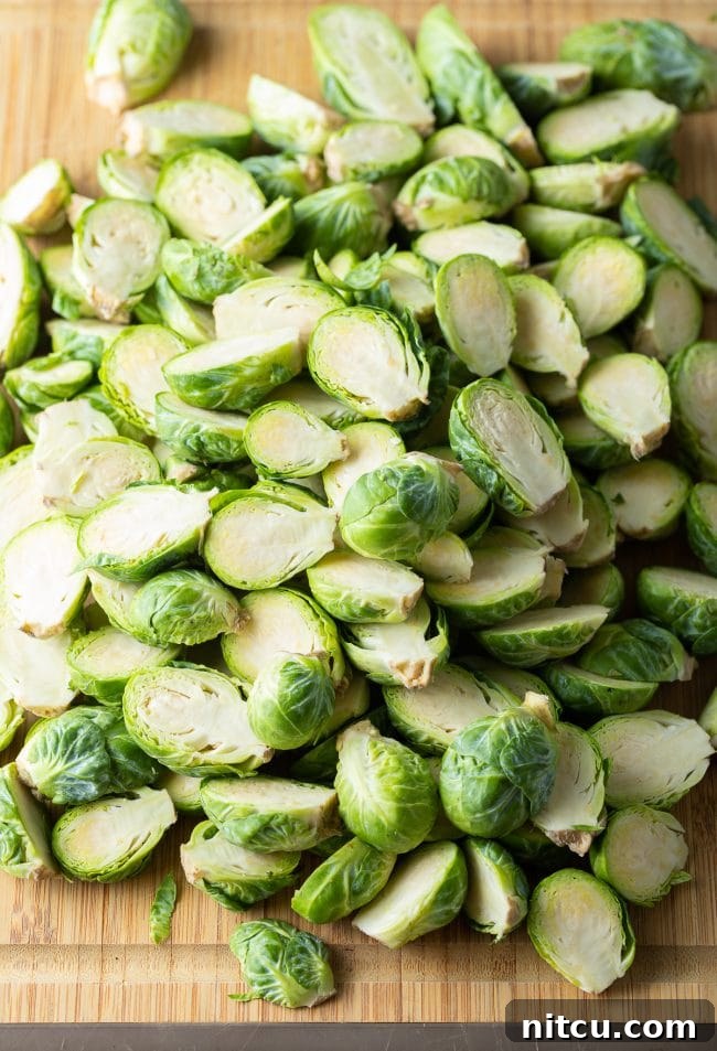Fresh sprouts cut in half on bamboo cutting board, showing preparation.