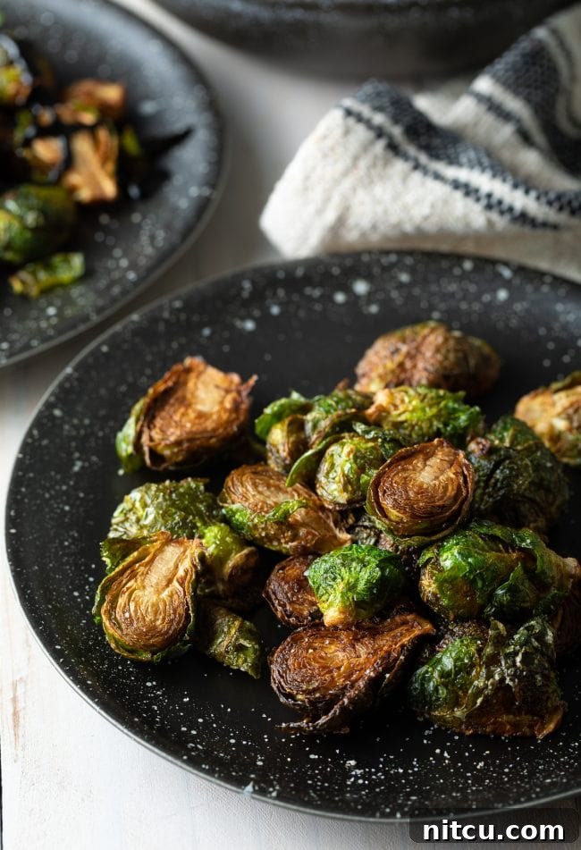 Plated crispy Brussels sprouts, elegantly arranged and garnished.