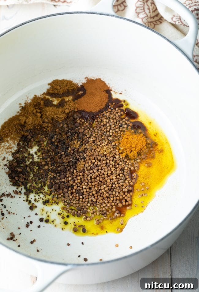 Spices and olive oil sizzling in a pot, forming the aromatic base for Mujadara.