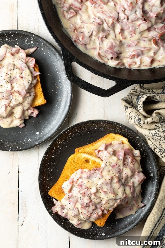 Two plates featuring generous servings of cream chipped beef on toast, inviting and comforting.