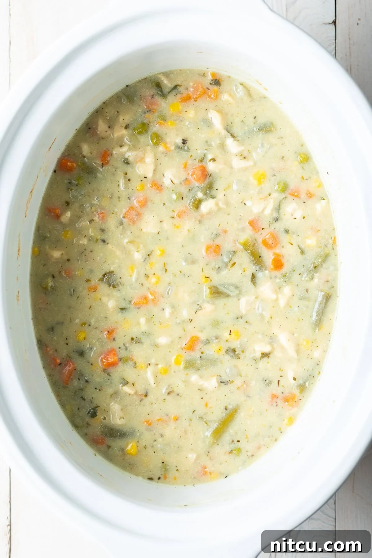 Slow cooker chicken pot pie in a large white crock