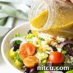 A close-up of the finished Greek Salad Dressing in a jar.