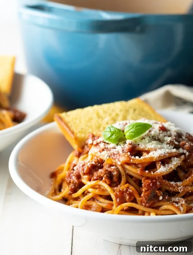 Spaghetti with meat sauce in a bowl served with garlic bread. 