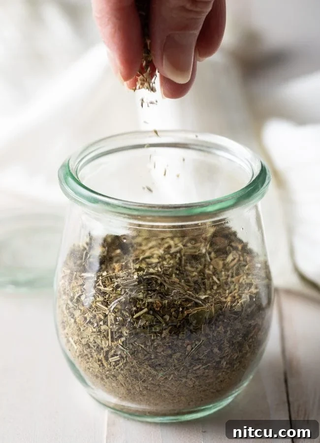 Homemade Italian seasoning in a glass jar, ready for use in cooking.