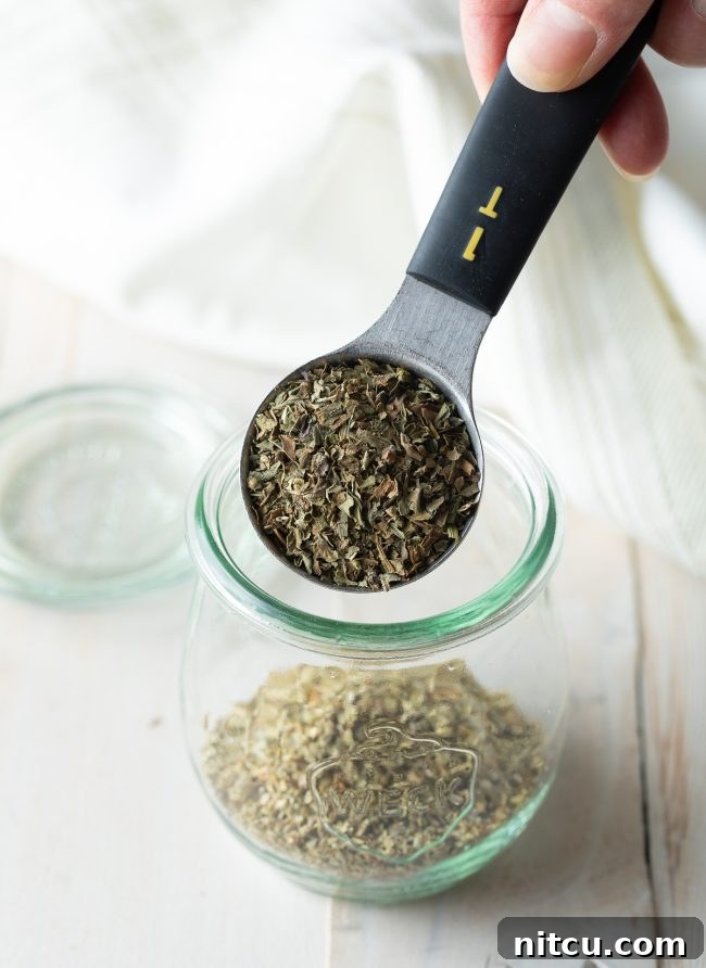 Close-up of a variety of dried Italian herbs and spices, showcasing their textures and colors.