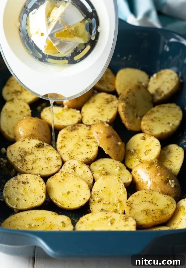 Lemon and seasonings drizzled over potatoes in casserole dish.