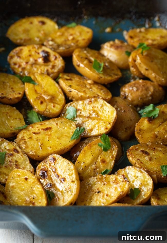 Roasted lemon garlic potatoes in a blue baking dish.