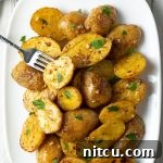 Miniature potatoes with lemon slices and herbs.