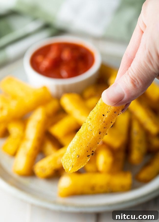 A plate of golden, crispy baked polenta fries, ready to be enjoyed.