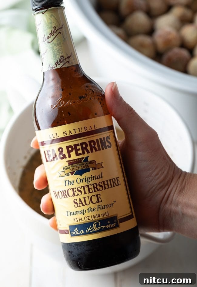 A bottle of Worcestershire sauce, a key ingredient for authentic Swedish Meatball flavor, displayed on a wooden surface.