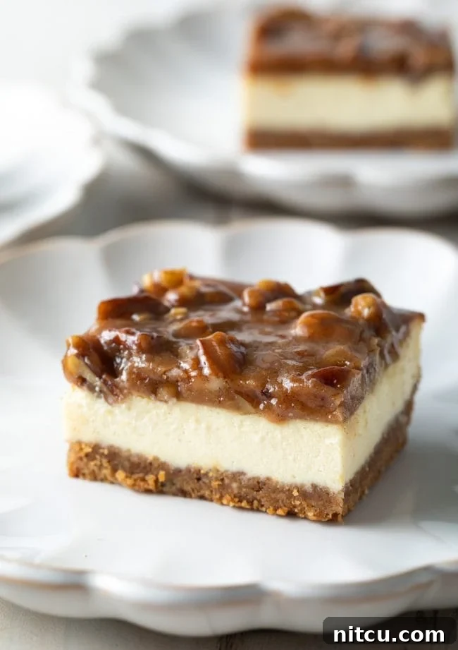 A slice of Pecan Pie Cheesecake bar on a white plate, showcasing the three distinct layers: graham cracker crust, creamy cheesecake, and rich pecan topping.